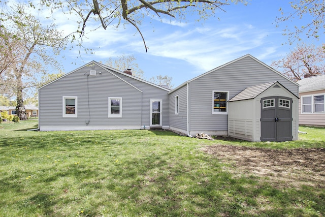 rear view of property featuring an outdoor structure, a lawn, a storage shed, and a chimney