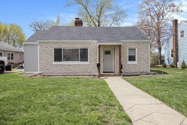 bungalow with roof with shingles, a chimney, stone siding, and a front yard