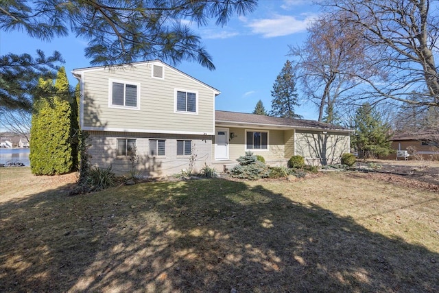 split level home featuring brick siding and a front yard