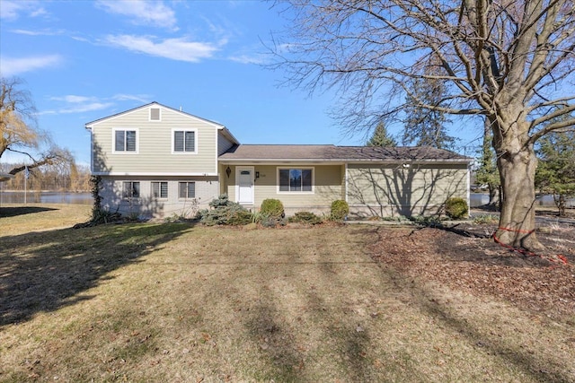 split level home with a front yard and a water view