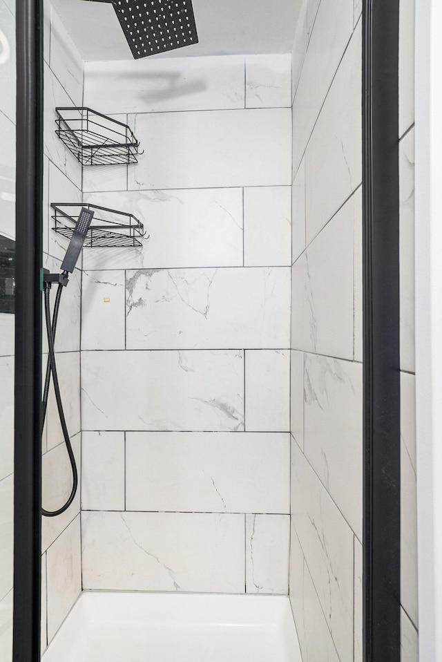 interior details featuring a tile shower