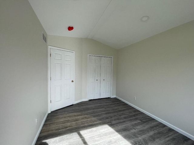 46132 Royal Dr, Chesterfield, MI 48051 - unfurnished bedroom featuring baseboards, visible vents, dark wood-style floors, and lofted ceiling