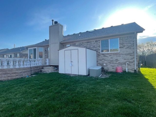 46132 Royal Dr, Chesterfield, MI 48051 - rear view of house featuring brick siding, a shed, an outbuilding, a chimney, and a lawn
