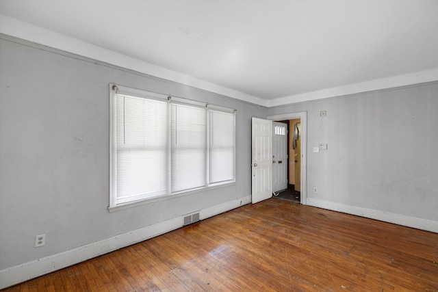 empty room featuring baseboards, plenty of natural light, and visible vents
