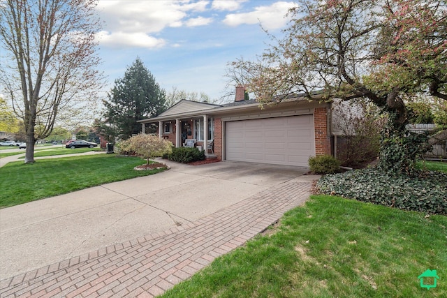 greek revival inspired property featuring concrete driveway, a front yard, an attached garage, and brick siding