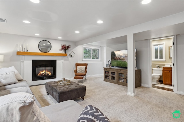 living room featuring visible vents, baseboards, carpet floors, a glass covered fireplace, and recessed lighting