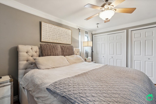bedroom featuring ornamental molding, ceiling fan, and two closets