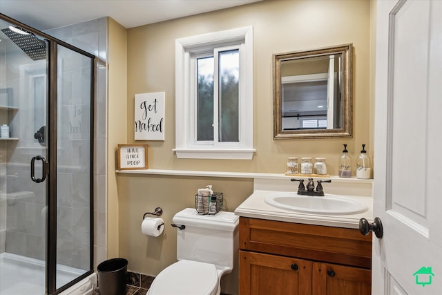 bathroom featuring toilet, a shower stall, and vanity