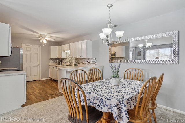 3380 Kneeland Cir, Howell, MI 48843 - dining space with a chandelier, baseboards, dark carpet, and a ceiling fan
