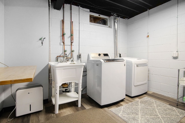 washroom with laundry area, washer and clothes dryer, and light wood-style flooring