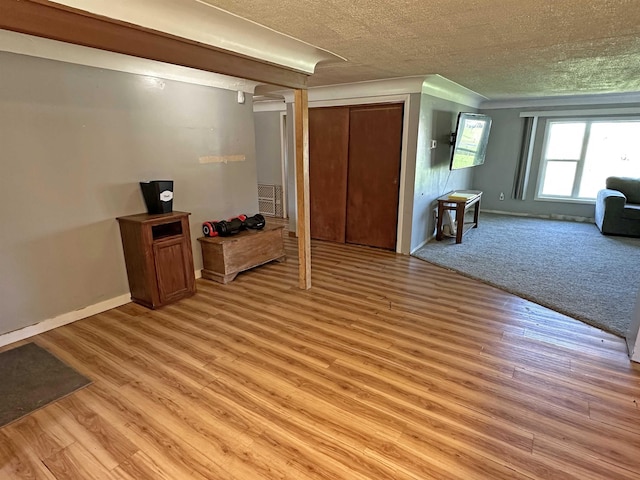2086 Sloan Rd, Burt, MI 48417 - living area featuring a textured ceiling, light wood finished floors, and baseboards