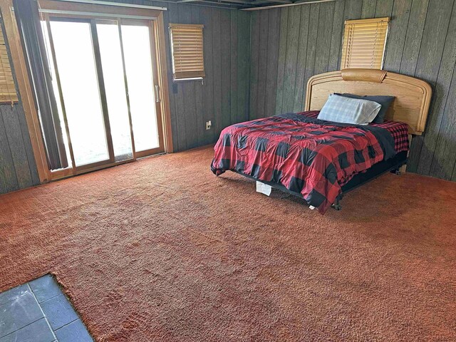 2086 Sloan Rd, Burt, MI 48417 - bedroom with wood walls, access to outside, and carpet floors