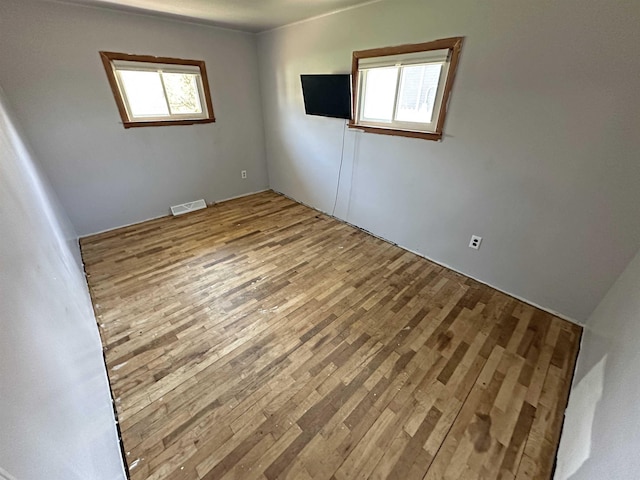 2086 Sloan Rd, Burt, MI 48417 - empty room with wood finished floors, visible vents, and plenty of natural light