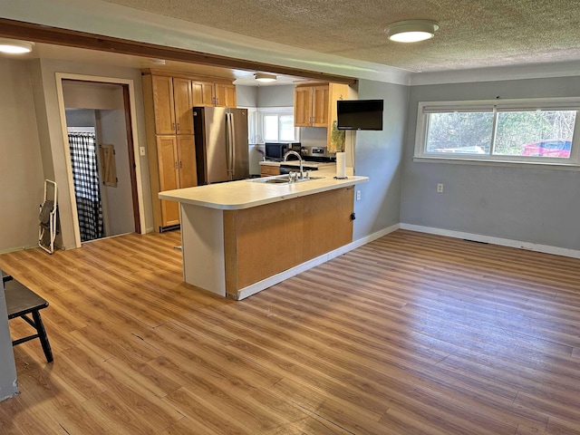 2086 Sloan Rd, Burt, MI 48417 - kitchen featuring a textured ceiling, black microwave, freestanding refrigerator, light wood finished floors, and a peninsula