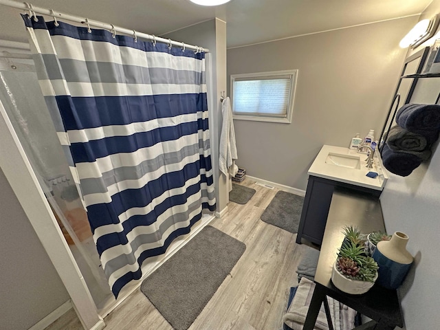 2086 Sloan Rd, Burt, MI 48417 - full bathroom featuring curtained shower, vanity, wood finished floors, and baseboards