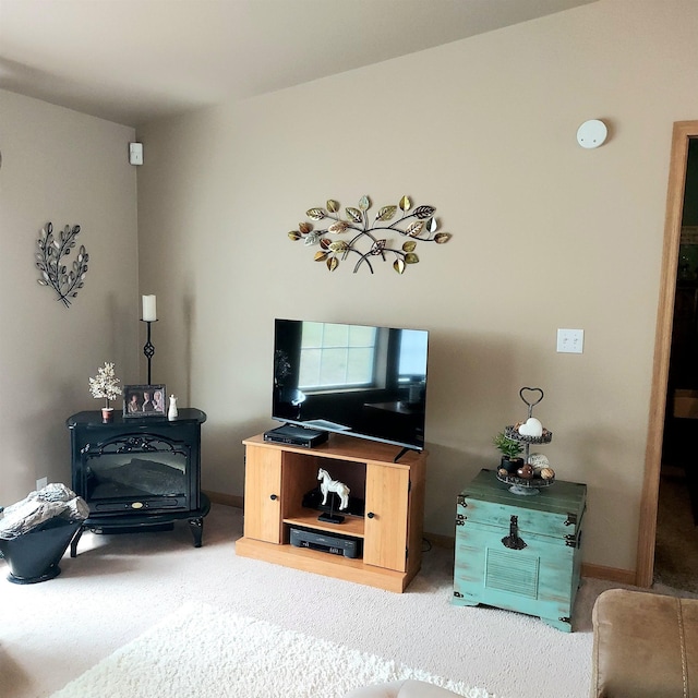 living area with a wood stove and carpet flooring