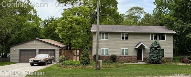 11520 Weiman Dr, Pinckney, MI 48169 - view of front facade featuring an outdoor structure, a garage, view of wooded area, and brick siding