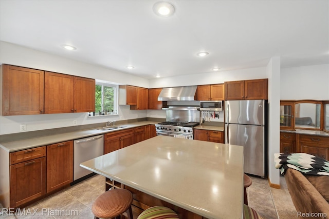 11520 Weiman Dr, Pinckney, MI 48169 - kitchen with appliances with stainless steel finishes, wall chimney range hood, a breakfast bar area, a sink, and brown cabinetry