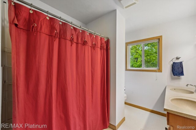 11520 Weiman Dr, Pinckney, MI 48169 - full bathroom with toilet, double vanity, a shower with curtain, and baseboards