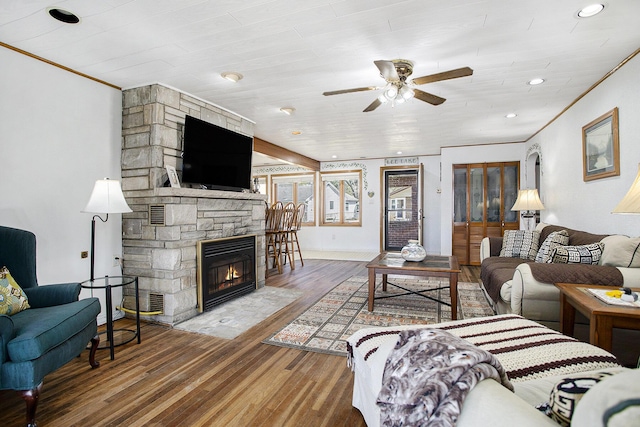 living area with recessed lighting, a fireplace, ceiling fan, ornamental molding, and wood finished floors