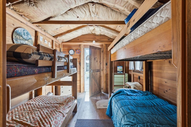 3895 Pine St, Glennie, MI 48737 - bedroom featuring hardwood / wood-style floors, vaulted ceiling, and wooden walls