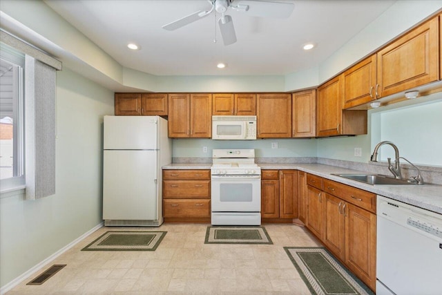 kitchen with a sink, brown cabinets, white appliances, baseboards, and light countertops