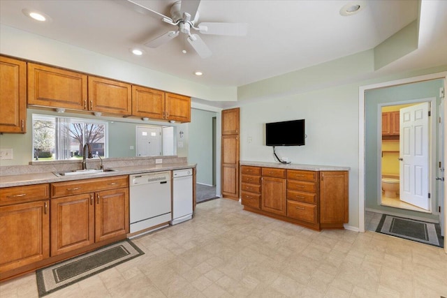 kitchen featuring a sink, ceiling fan, brown cabinetry, light countertops, and dishwasher