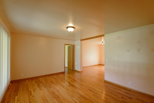 empty room with baseboards and light wood finished floors