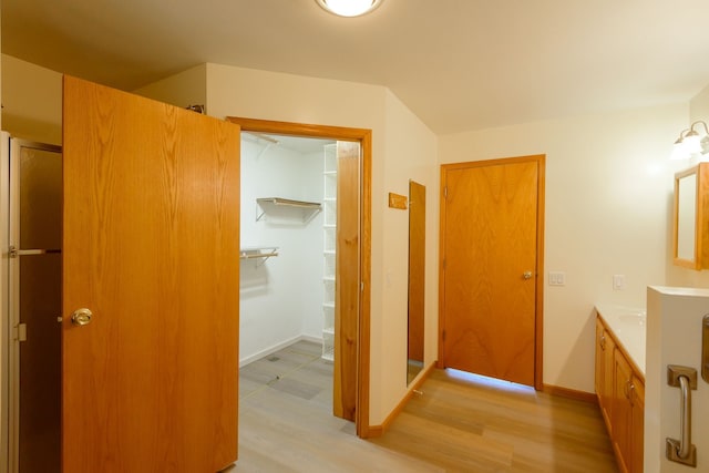 bathroom with baseboards, wood finished floors, and vanity