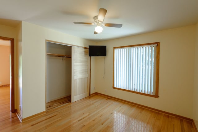 unfurnished bedroom with baseboards, a ceiling fan, a closet, and light wood-style flooring