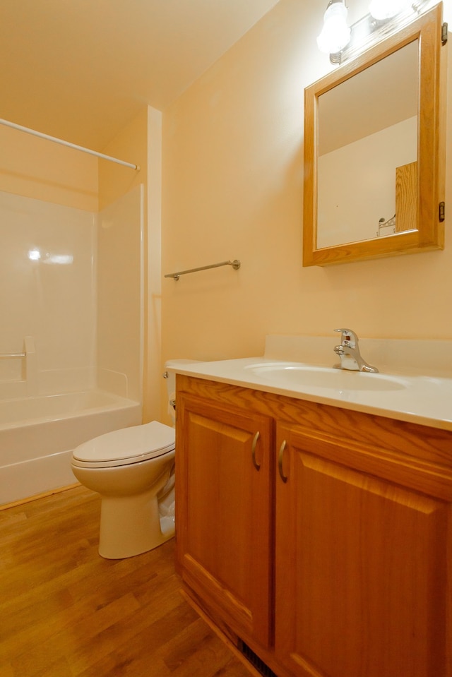 full bathroom with vanity, toilet, wood finished floors, and shower / washtub combination