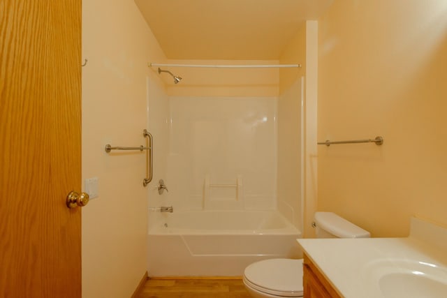 full bathroom with vanity, washtub / shower combination, wood finished floors, and toilet