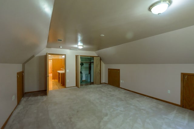 additional living space featuring carpet flooring, baseboards, vaulted ceiling, and visible vents