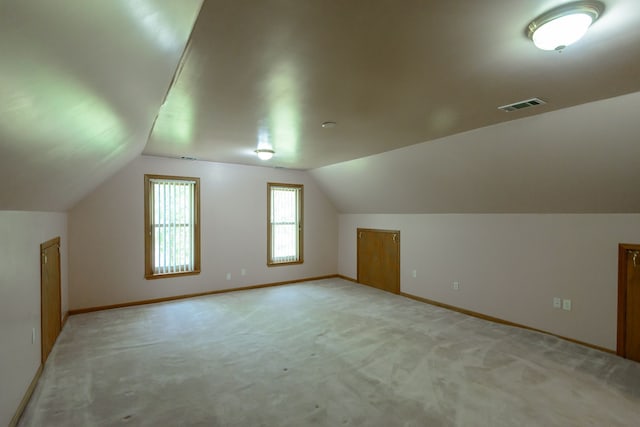 bonus room with carpet flooring, baseboards, vaulted ceiling, and visible vents