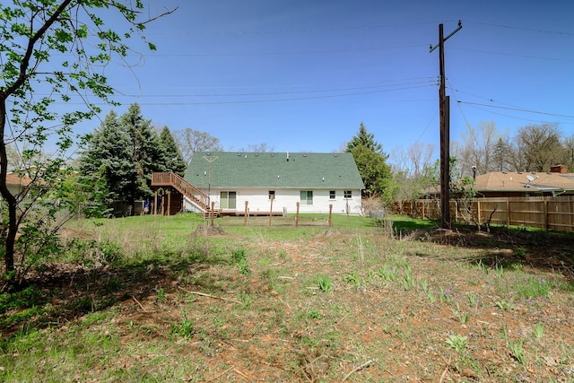 view of yard featuring a wooden deck, fence, and stairway