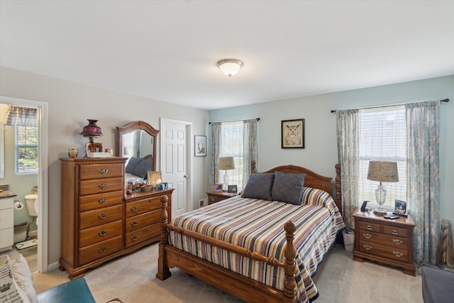 bedroom with light carpet and ensuite bath