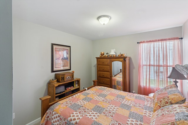 bedroom with baseboards and multiple windows
