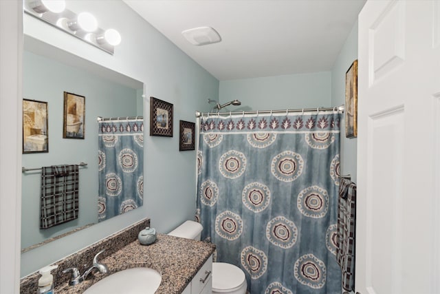 bathroom featuring vanity, curtained shower, and toilet