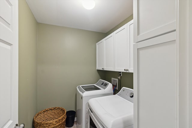 washroom featuring cabinet space and washing machine and clothes dryer