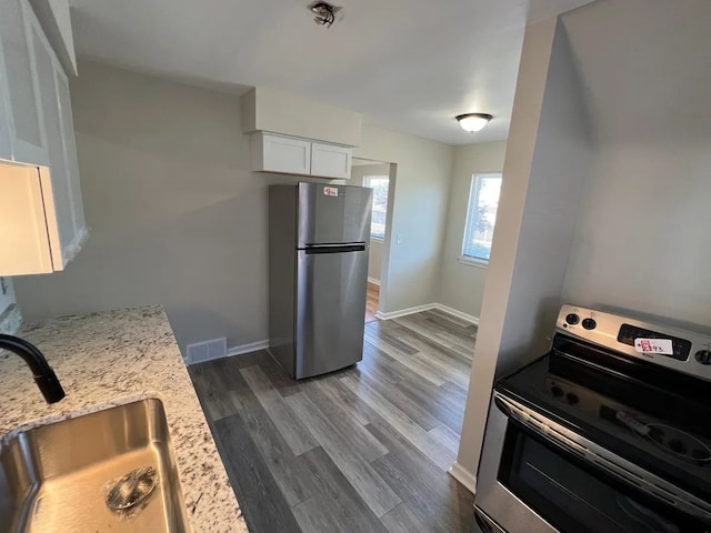 kitchen featuring visible vents, dark wood-type flooring, white cabinetry, a sink, and stainless steel appliances