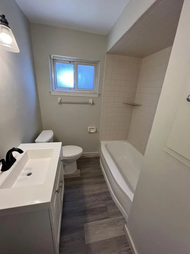 bathroom with toilet, wood finished floors, and vanity