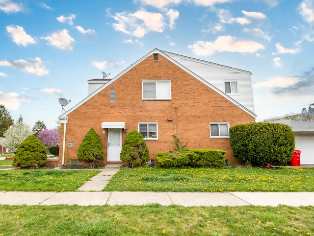 view of front of house with a chimney, a front yard, and brick siding