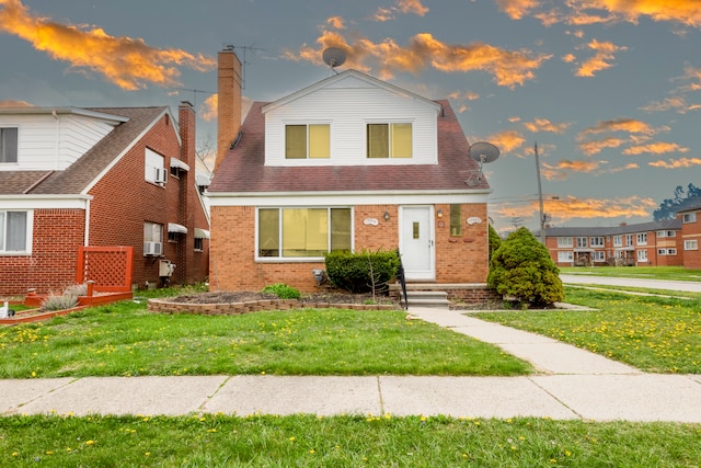view of front facade with a chimney, a front lawn, and brick siding