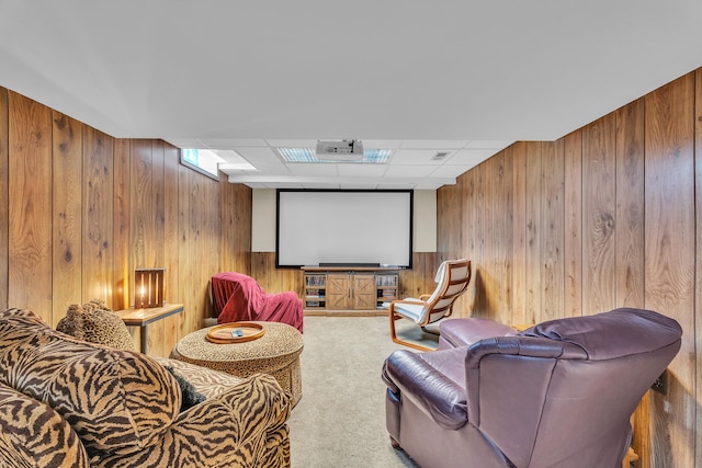 home theater featuring wood walls, carpet, and a paneled ceiling