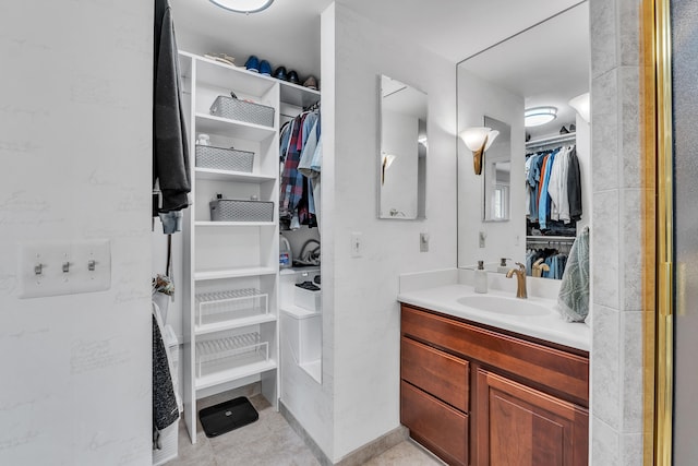 bathroom featuring tile patterned flooring, vanity, and a spacious closet