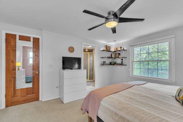 bedroom with ensuite bathroom, baseboards, a ceiling fan, and light carpet