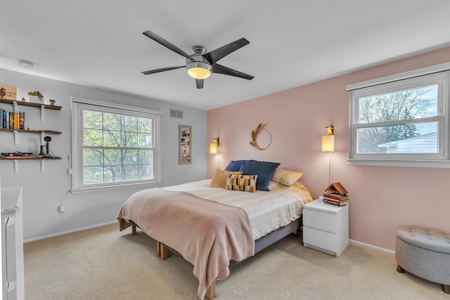 bedroom featuring baseboards, visible vents, ceiling fan, and light colored carpet