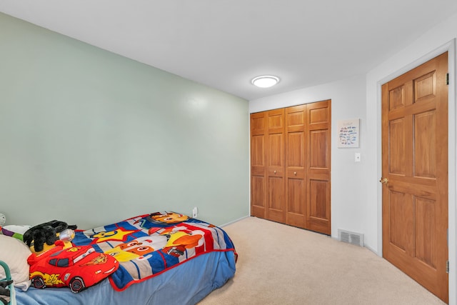 carpeted bedroom with a closet, visible vents, and baseboards