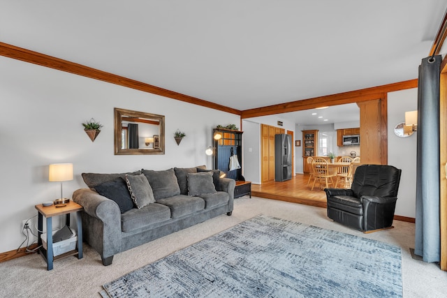 living room featuring baseboards, recessed lighting, light carpet, and crown molding