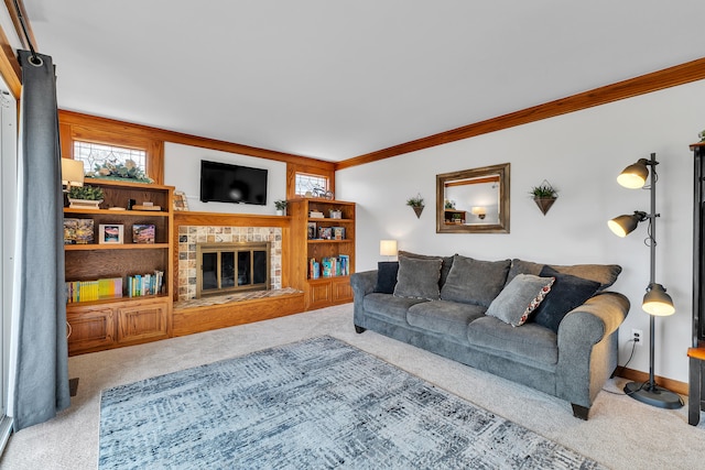 living area with baseboards, ornamental molding, carpet flooring, and a glass covered fireplace
